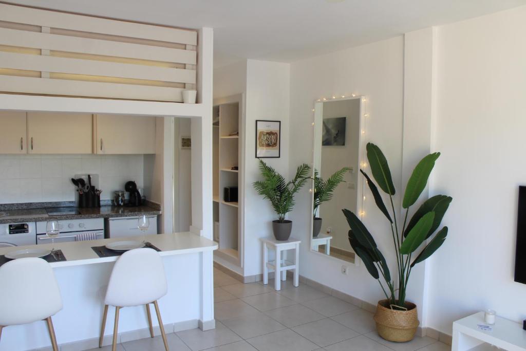 cocina y sala de estar con armarios blancos y plantas en Pachi Beach Atlantic Garden Corralejo, en Corralejo