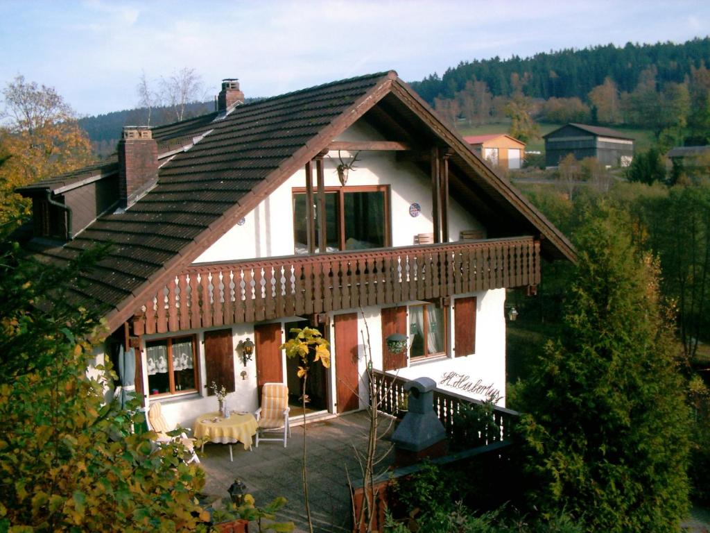 a house with a wooden roof with a porch at Ferienwohnung Sankt Hubertus in Bad Berneck im Fichtelgebirge