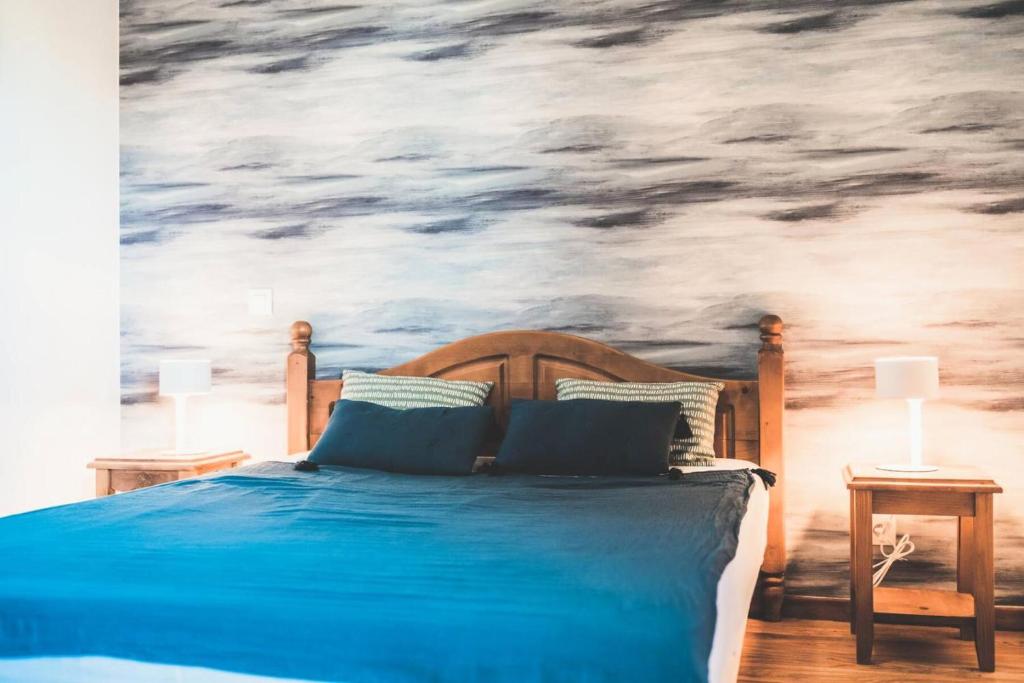 ein Schlafzimmer mit einem blauen Bett mit einem Bild von Wolken in der Unterkunft Résidence Les Eglantines - 2 Pièces pour 6 Personnes 804 in Les Orres