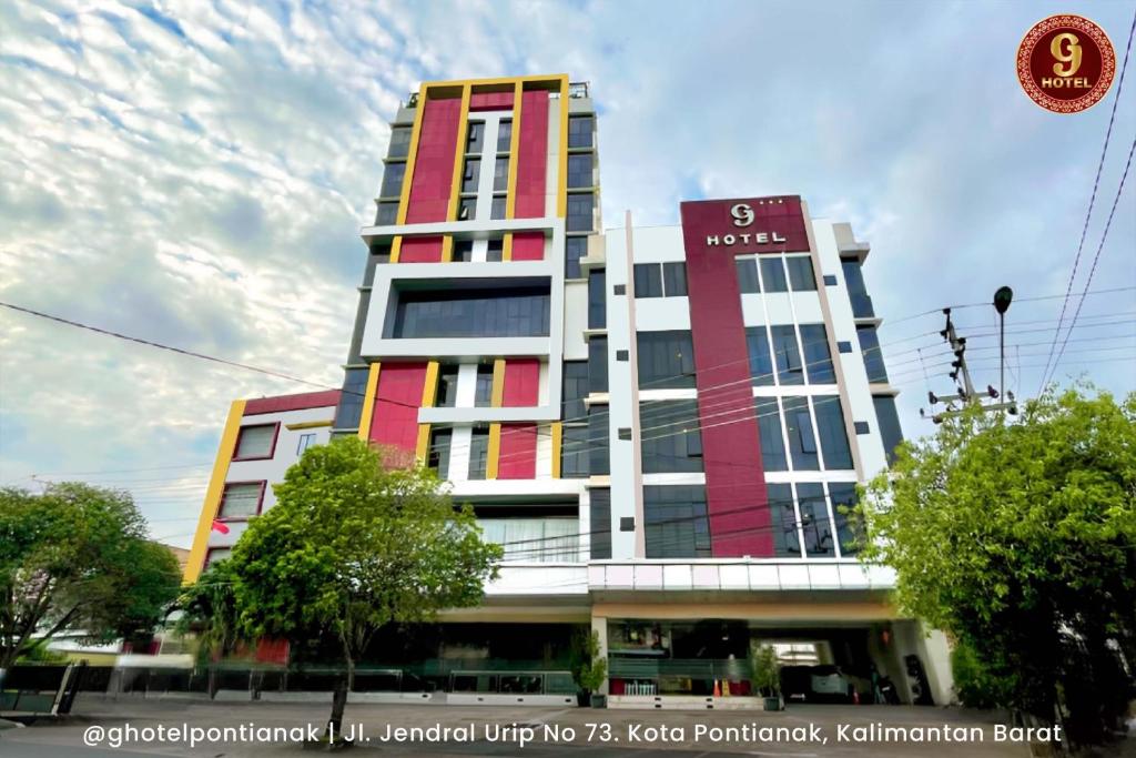 a tall building with a sign on top of it at G-Hotel Pontianak in Pontianak