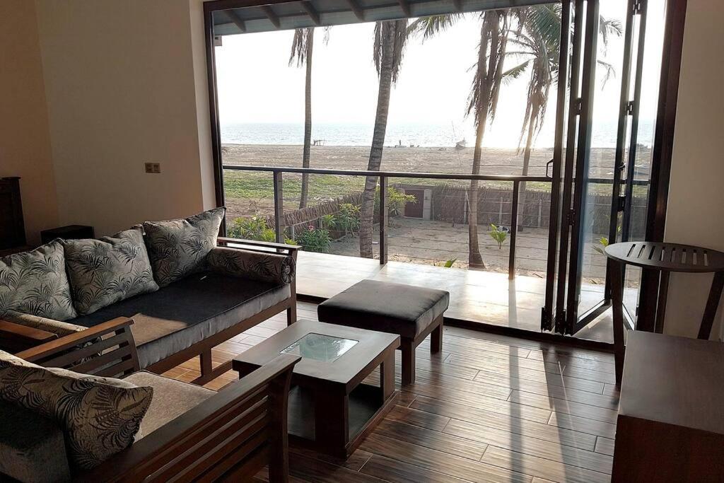 salon z kanapą i widokiem na plażę w obiekcie Nayan's Paradise Beach Villa w mieście Puttalam