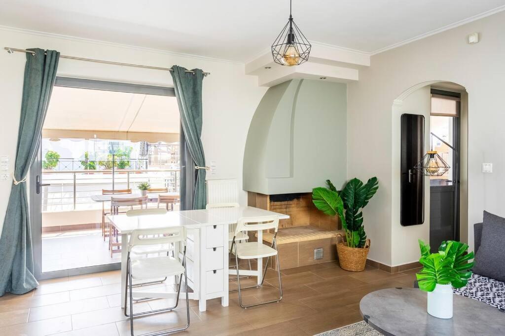 sala de estar con mesa blanca y sillas en Comfort 1BR apt with amazing balcony at Piraeus, en Pireo