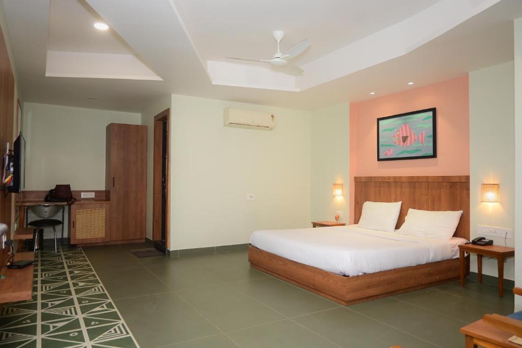 1 dormitorio con cama y escritorio. en Hotel Ashray en Ujjain