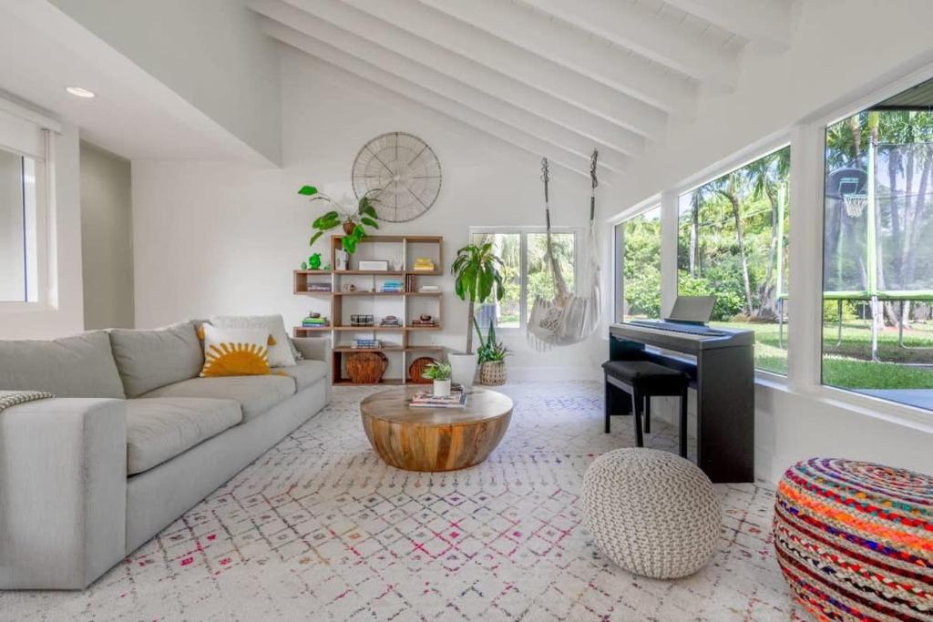 a living room with a couch and a table and a piano at Boho House - Stylist Home with Parking and large Yard in Miami