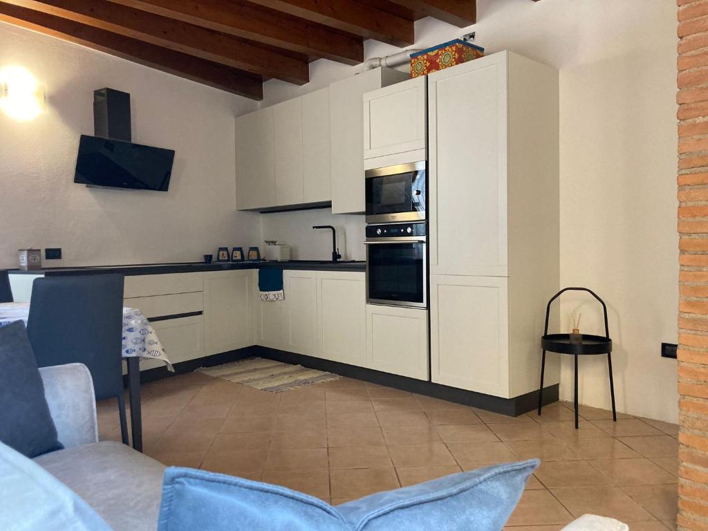 een keuken met witte kasten en een fornuis met oven bij Il Volto in Valeggio sul Mincio