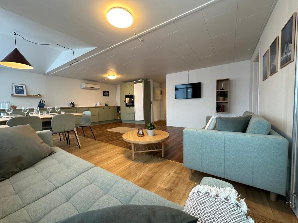 a living room with a couch and a table at Det grønne hus med isbjergsudsigt in Ilulissat