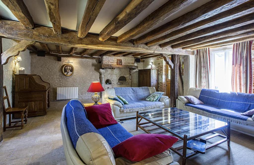 un salon avec des canapés bleus et une table en verre dans l'établissement Lodge de Loire - rive droite - proche Chambord, à Séris