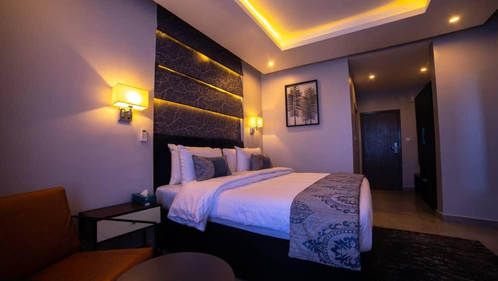 1 dormitorio con 1 cama grande en una habitación de hotel en Blue Apple Hotel, en Lekki