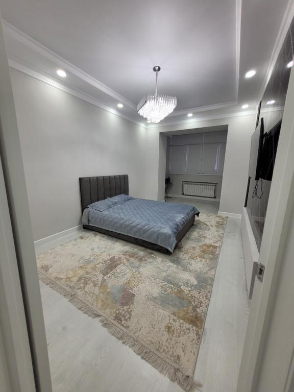 1 dormitorio con cama y alfombra grande en Квартира 1- комнатная, en Aktobe