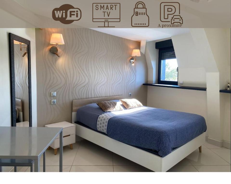 - une chambre avec un lit bleu et une table dans l'établissement RDC 4 - Studio meublé centre ville de Montluçon, à Montluçon