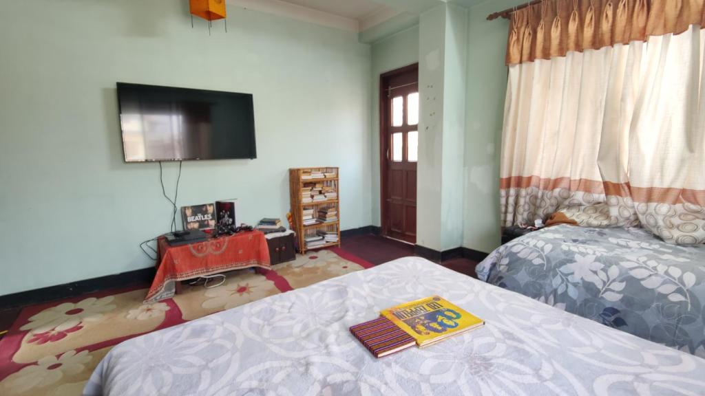 a bedroom with a bed and a flat screen tv at Family Home with Rooftop access and Mountain View in Kathmandu