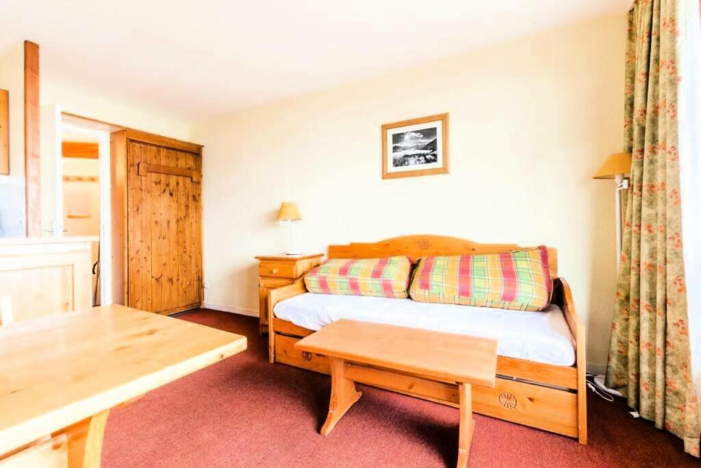 une petite chambre avec un lit et une table dans l'établissement Résidences quartier Charmettoger - maeva Home - Appartement 2 Pièces 5 Personnes - Budget MAE-9914, à Arc 1800