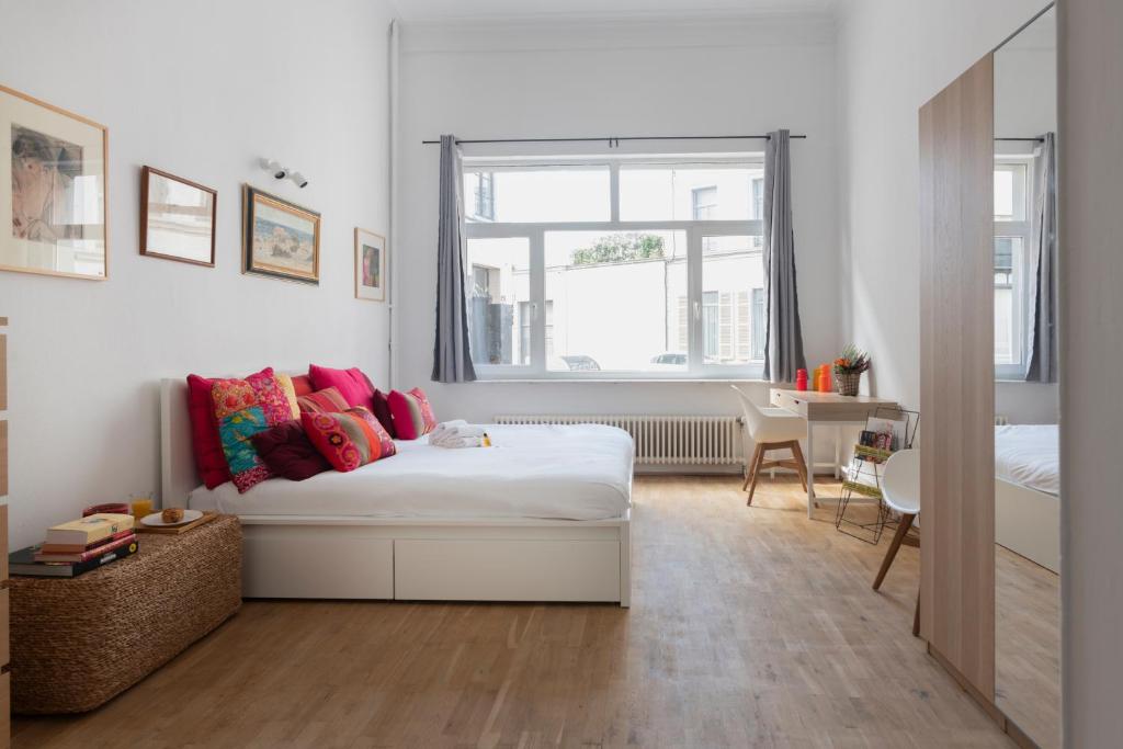 um quarto com uma cama com almofadas coloridas em Brussels Benit Ixelles Residence em Bruxelas