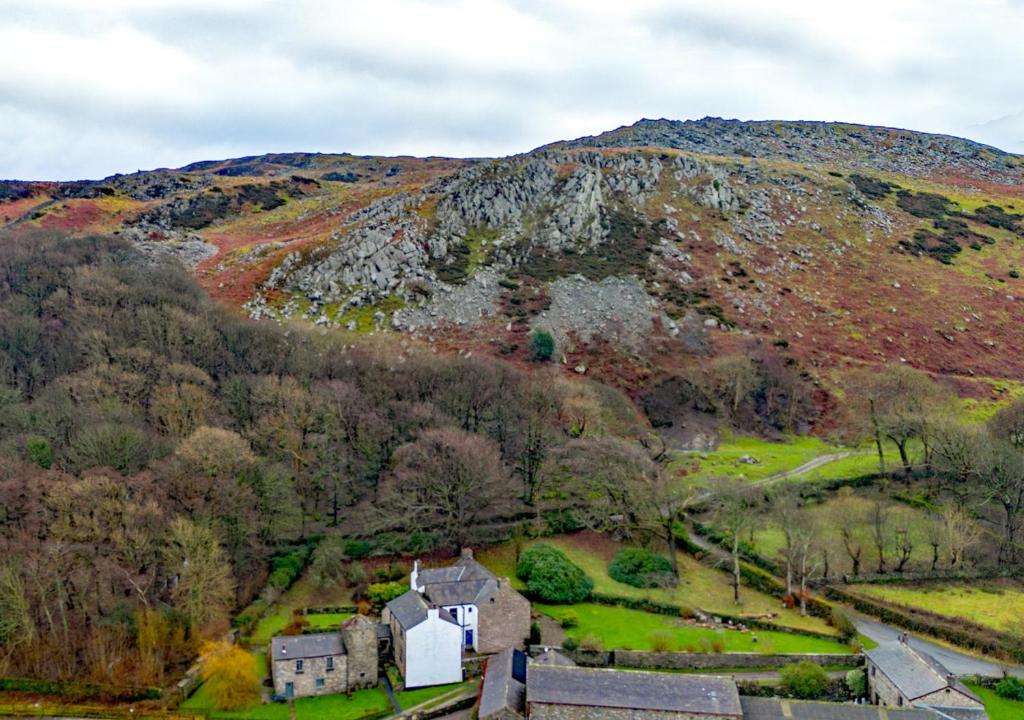 an aerial view of a hill with a house and trees at Fell View in Silecroft