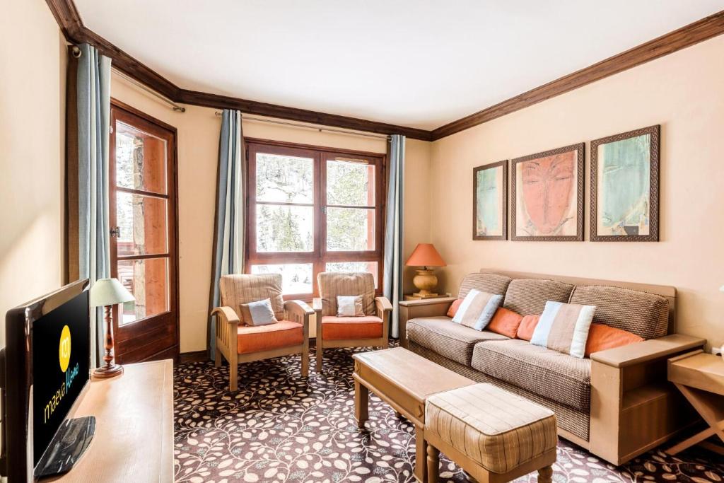 un salon avec un canapé et une télévision dans l'établissement Résidence Les Arcs 1950 Le Village - maeva Home - Appartement 2 pièces 4 personnes - Sélection MAE-0524, à Bourg-Saint-Maurice