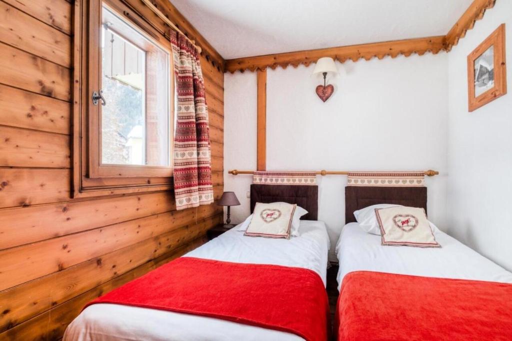 two twin beds in a room with wooden walls at Résidence La Ginabelle - maeva Home - Appartement 4 Pièces 8 Personnes - S 444 in Chamonix
