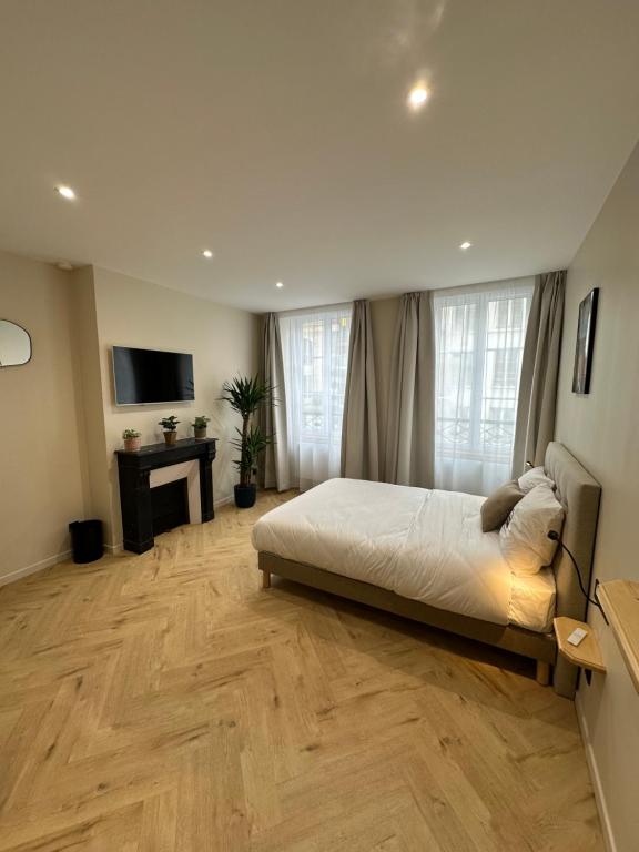 a bedroom with a bed and a wooden floor at Les Chambres du Faubourg in Paris