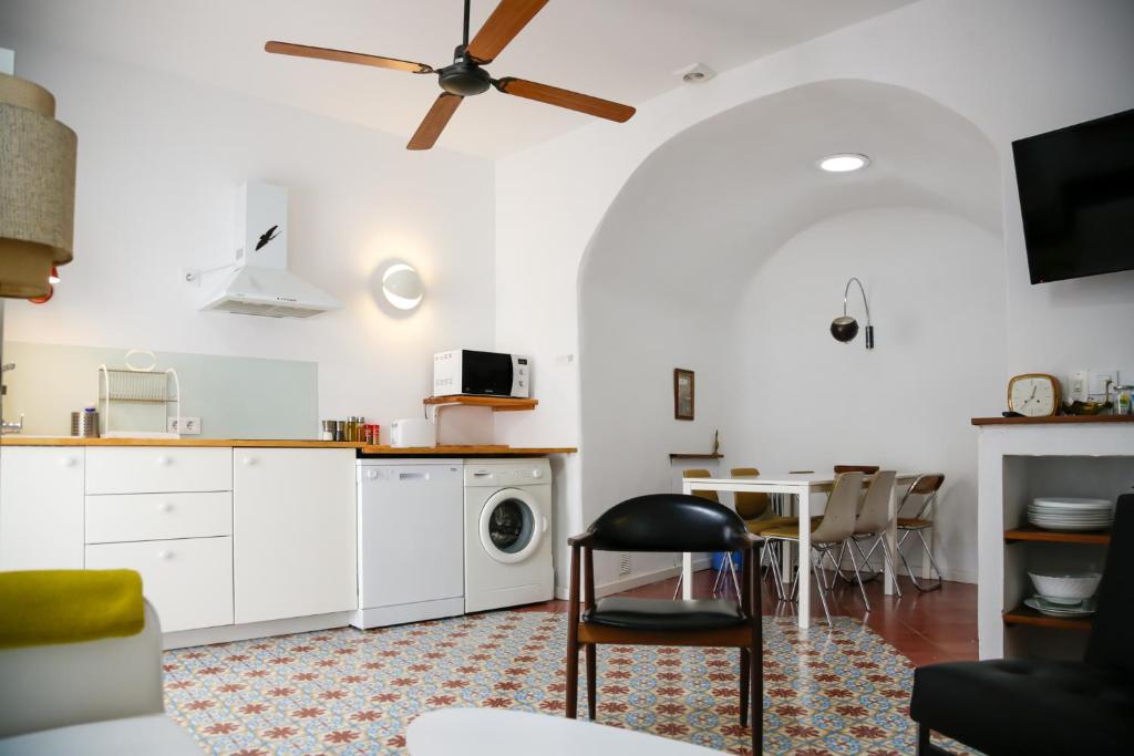 a kitchen with white cabinets and a washer and dryer at Vejerísimo Casa Boutique in Vejer de la Frontera