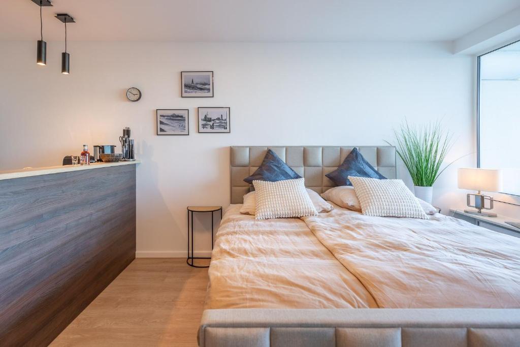 ein Schlafzimmer mit einem großen Bett mit blauen Kissen in der Unterkunft Haus Nautic, FeWo 115 in Döse