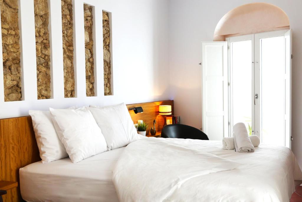 a bedroom with a large white bed with white pillows at Vejerísimo Casa Boutique in Vejer de la Frontera