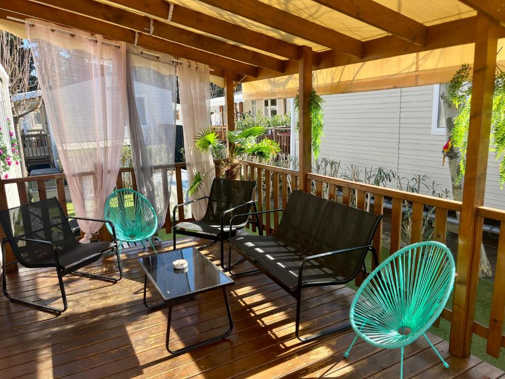 - une véranda avec des chaises et une table dans l'établissement Mobile home exotique de 40 m2, à Fréjus