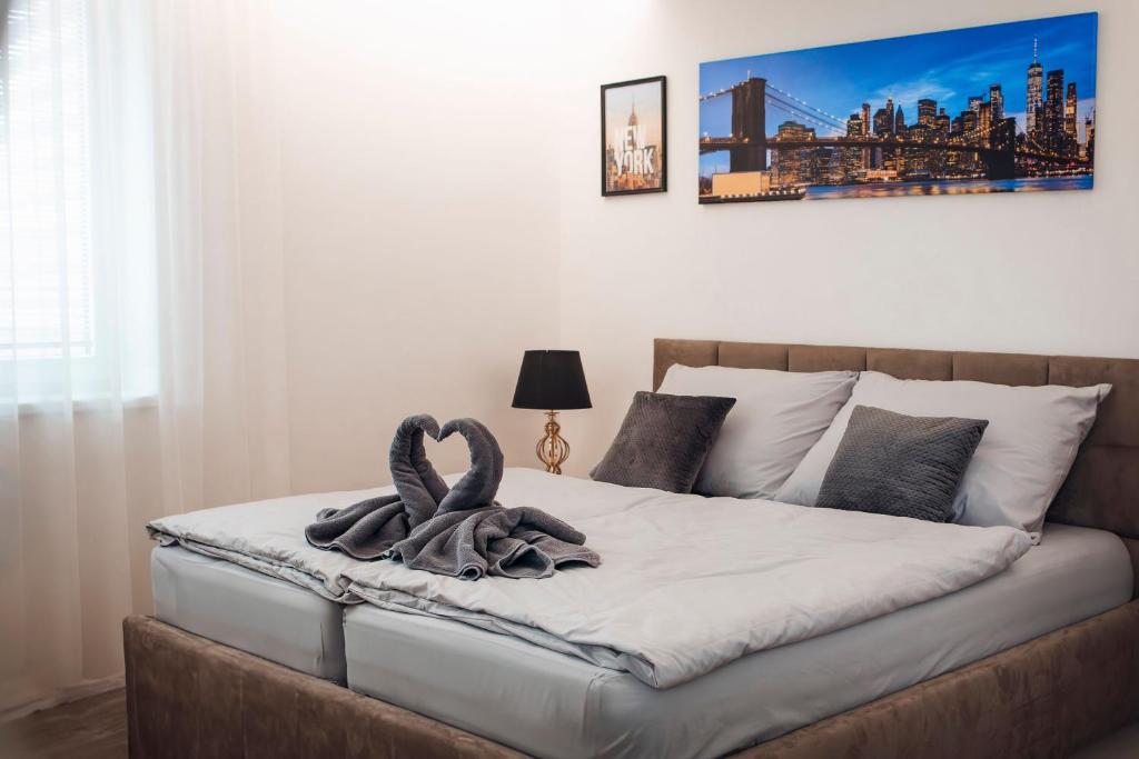 a bedroom with a bed with a swan towel on it at Apartman New York in Podhájska