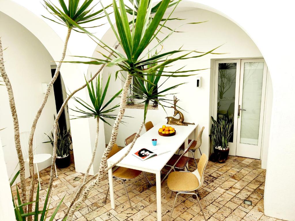 a white table with chairs and plants in a room at Vejerísimo Casa Boutique in Vejer de la Frontera