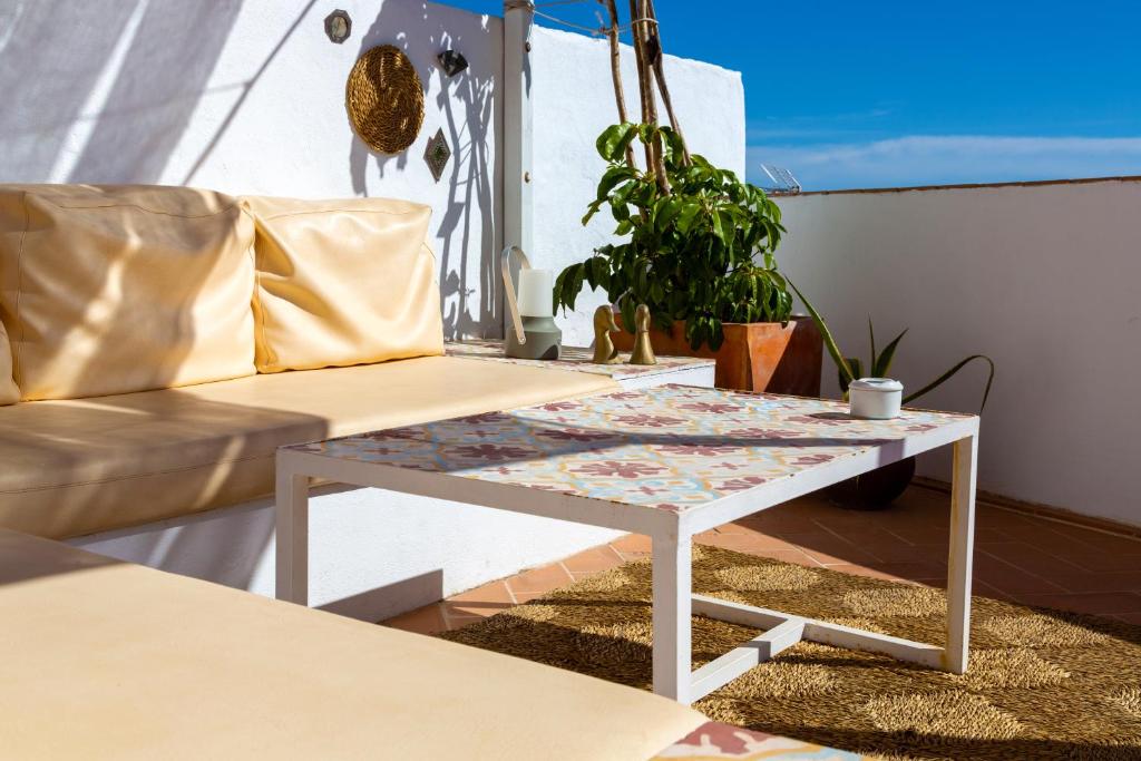 a coffee table on a balcony with a couch at Vejerísimo Casa Boutique in Vejer de la Frontera