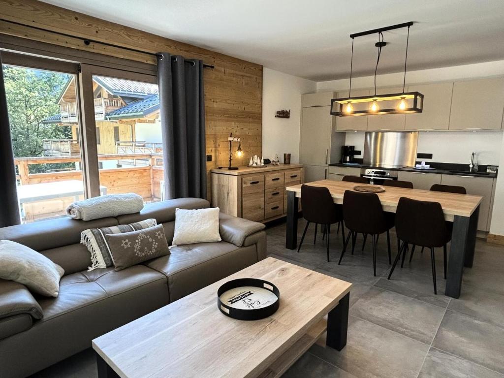 a living room with a couch and a table at Résidence LES TERRASSES DE LA VANOISE - Appartement LES TERRASSES DE LA VAN 924 in Champagny-en-Vanoise