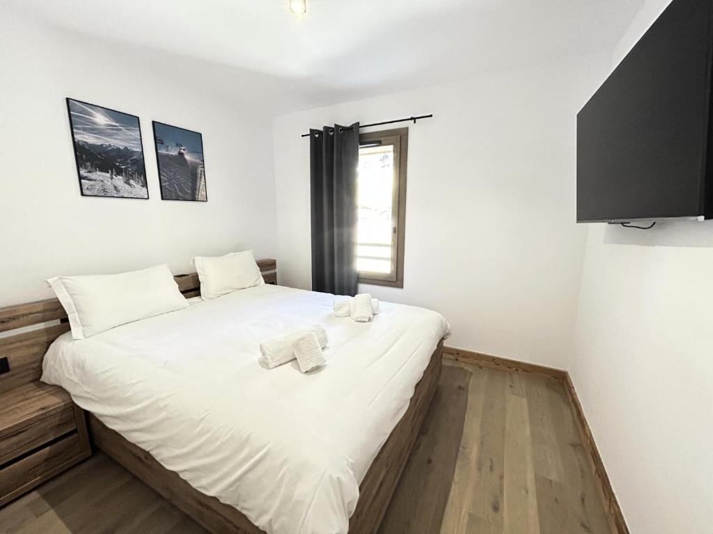 a bedroom with a large white bed with towels on it at Résidence LES TERRASSES DE LA VANOISE - Appartement LES TERRASSES DE LA VAN 924 in Champagny-en-Vanoise