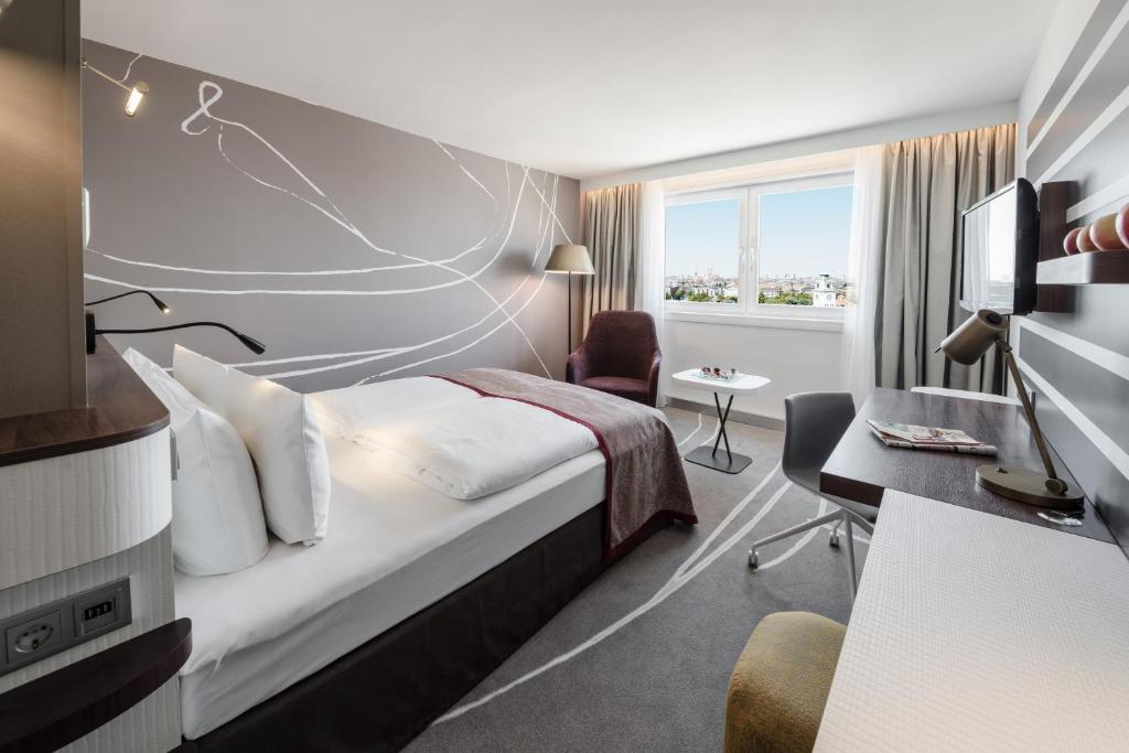una camera d'albergo con letto e scrivania di Holiday Inn Munich City Centre, an IHG Hotel a Monaco
