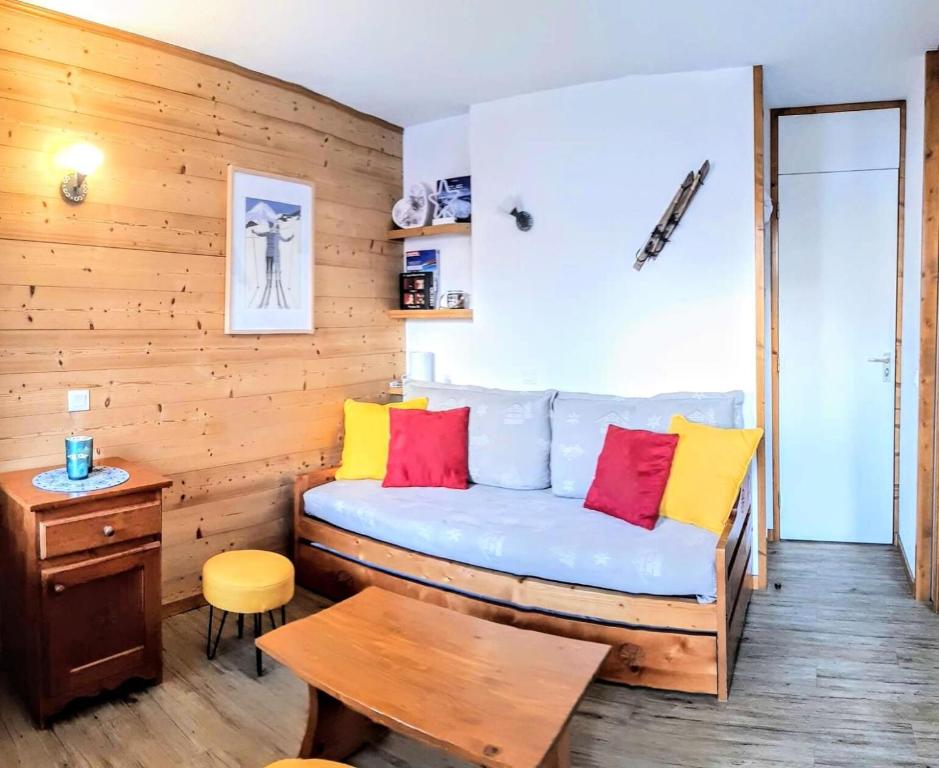 Cette chambre dispose d'un canapé bleu avec des oreillers colorés. dans l'établissement Résidence Lauziere Dessous - La Lauzière-Dessous 22 - Joli 2 pièces divisible, ski aux pieds MAE-5444, à Valmorel