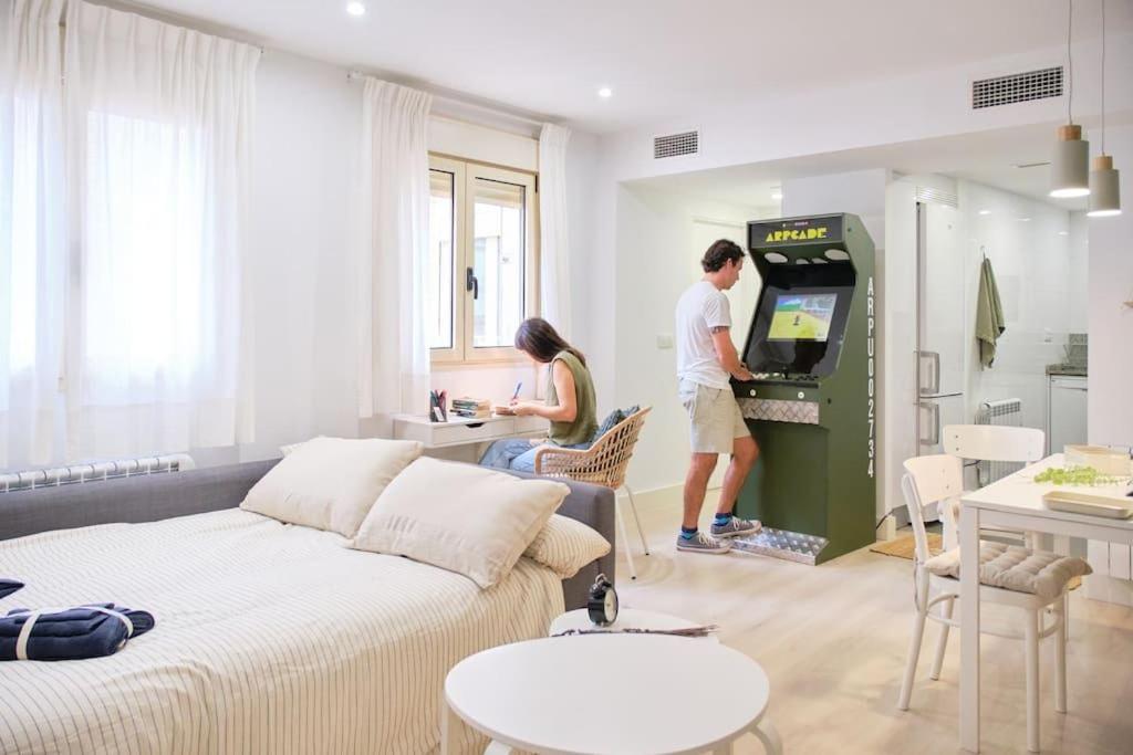 twee mensen die een videospel spelen in een woonkamer bij Villa Baturra l Centro l WiFi y Arcade in Zaragoza