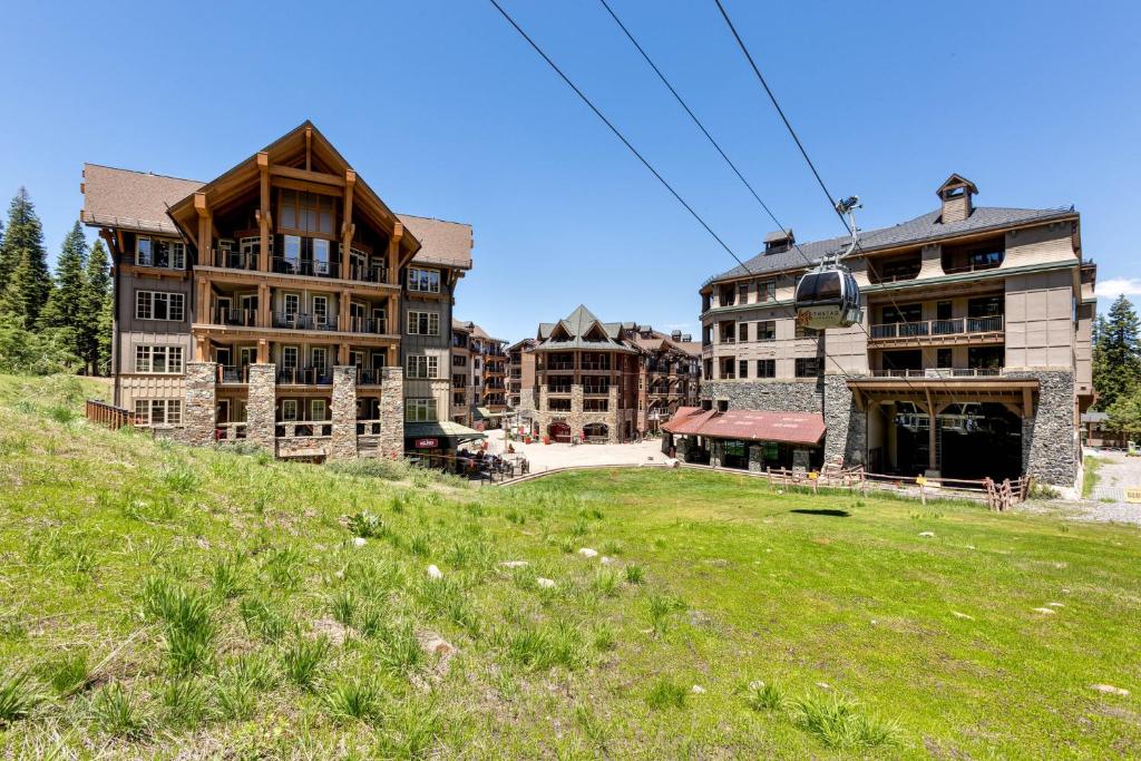 a group of buildings on a hill with a green field at Northstar California Resort in Truckee