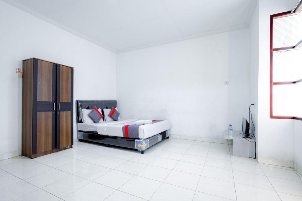 ジャカルタにあるJ&B Rooms Tomang Jakarta Mitra RedDoorzのベッドルーム(ベッド1台、テレビ付)