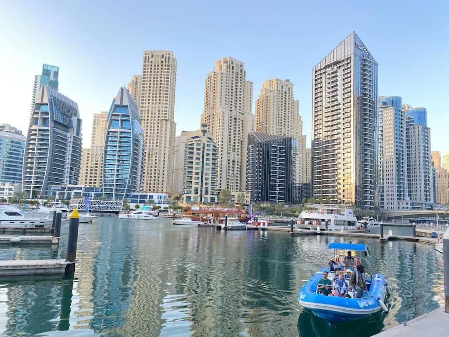 un grupo de personas en un barco en el agua en una ciudad en Elite Luxury - Spacious 2BR Apt 1517 Sqft in Dubai Marina Both bedroom Ensuite Walking to Metro Restaurants Beach Mall Marina walk, en Dubái