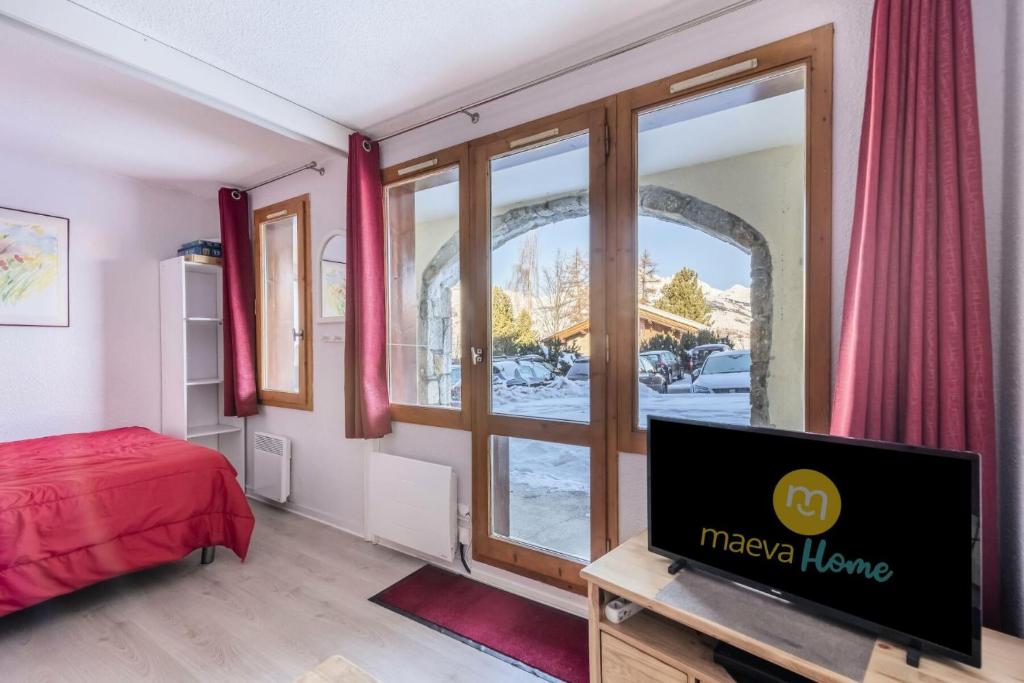 - une chambre avec une télévision et une fenêtre dans l'établissement Résidence Le Hameau du Sauget - maeva Home - Appartement 2 pièces 4 personnes - Confort MAE-3944, à La Plagne Tarentaise