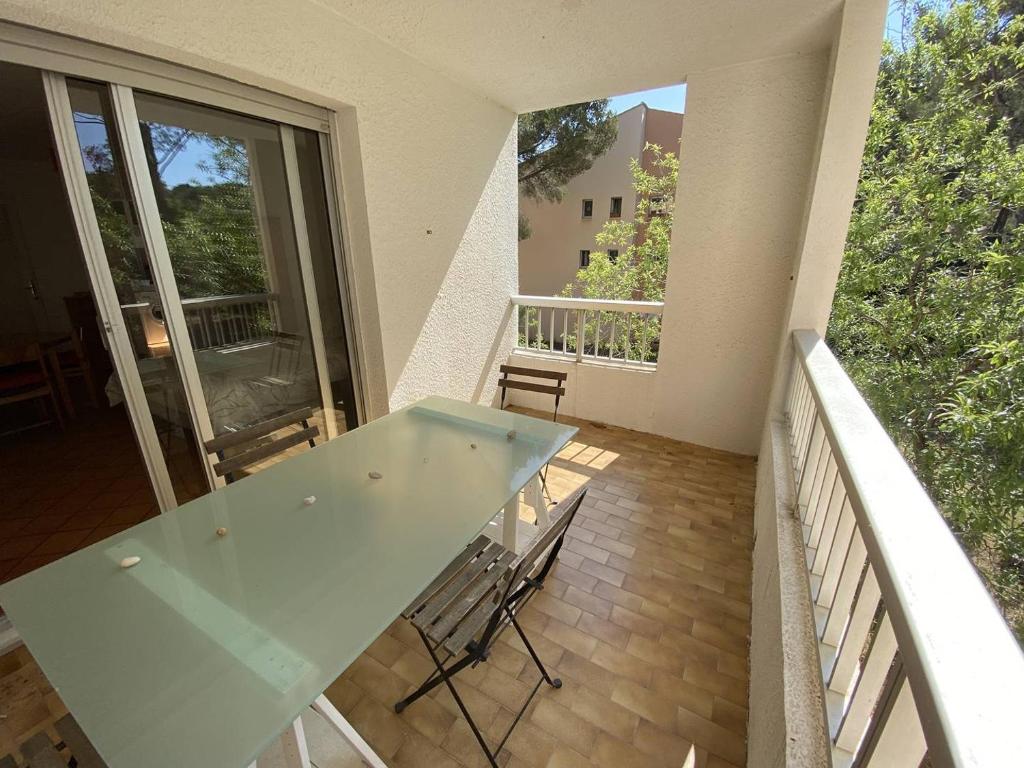 une table en verre sur le balcon d'une maison dans l'établissement Belle vue arborée dans résidence au calme, plage à pied, à Saint-Elme