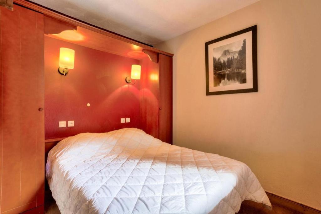 ein Schlafzimmer mit einem Bett und einem Bild an der Wand in der Unterkunft Quartier La Forêt - maeva Home - Appartement 2 pièces 5 personnes - Sélec 134 in Valmorel