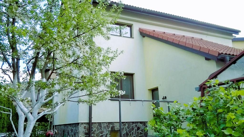 een wit huis met een hek en bomen bij Apartment Beatris in Svit