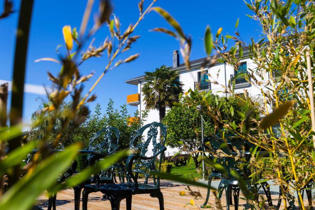 un groupe de bancs devant un bâtiment dans l'établissement Hotel O Cabazo, à Ribadeo