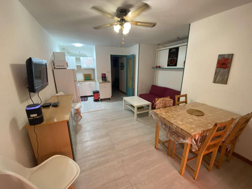 un salon avec une table et une salle à manger dans l'établissement Bel appartement climatisé en rez de jardin, plage à 200 m, idéal vacances, à Saint-Elme