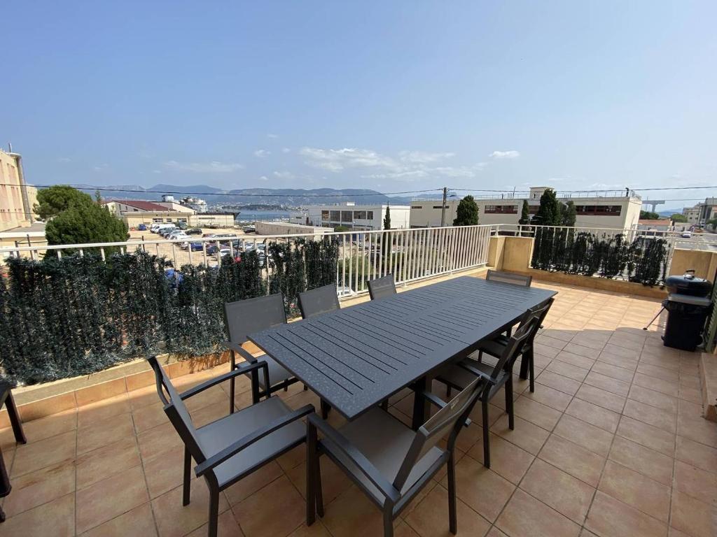 een tafel en stoelen op een balkon met uitzicht bij Vue mer au coeur de Saint Mandrier, 3 chambres, climatisation, wifi (fibre) in Saint-Mandrier-sur-Mer