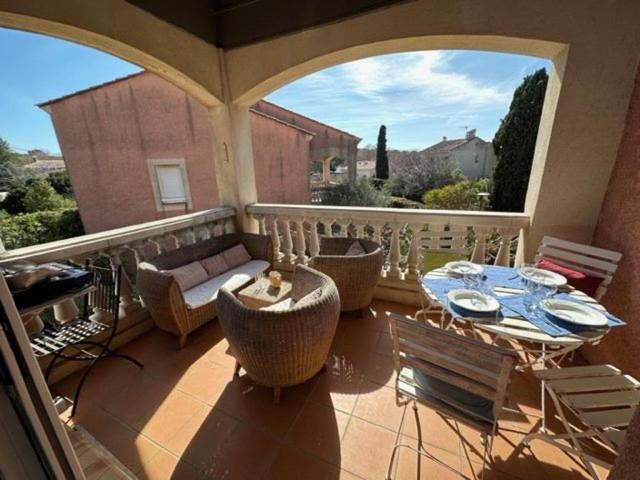 d'une terrasse avec une table et des chaises ainsi que d'un balcon. dans l'établissement Piscine, plage à pied, 2 chambres, à Six-Fours-les-Plages