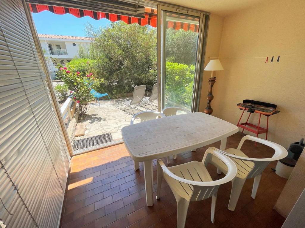 - une table et des chaises dans une chambre avec terrasse dans l'établissement Bord de plage, rez de jardin,5/7 personnes...WIFI, à Saint-Elme