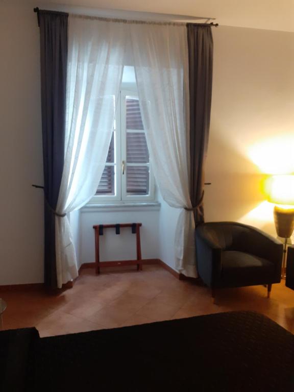 salon z oknem, krzesłem i lampką w obiekcie Interno 2 w Rzymie