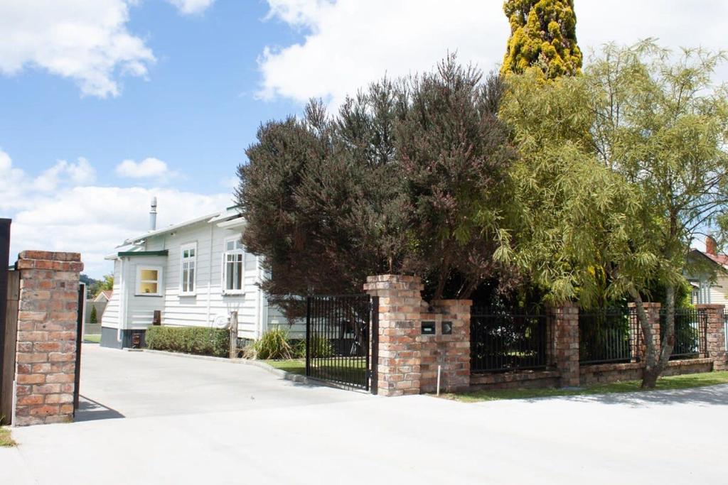 une clôture devant une maison avec un arbre dans l'établissement Central Villa Oasis, à Whangarei