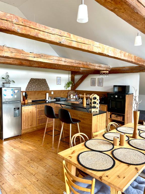 una cucina con pavimenti in legno, tavoli e sedie in legno di Rodinné apartmány Angelika a Česká Lípa