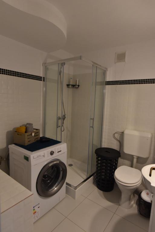 a bathroom with a washing machine and a toilet at Mall Apartment 100mp in Bacău