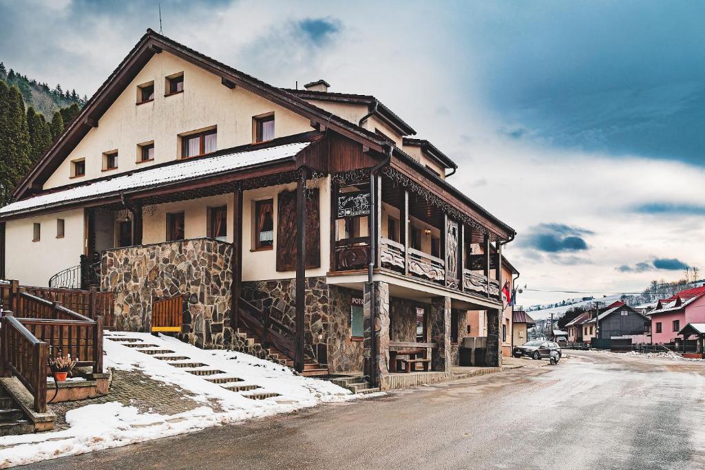 a house on the side of a snow covered street at U GORAĽA in Lesnica